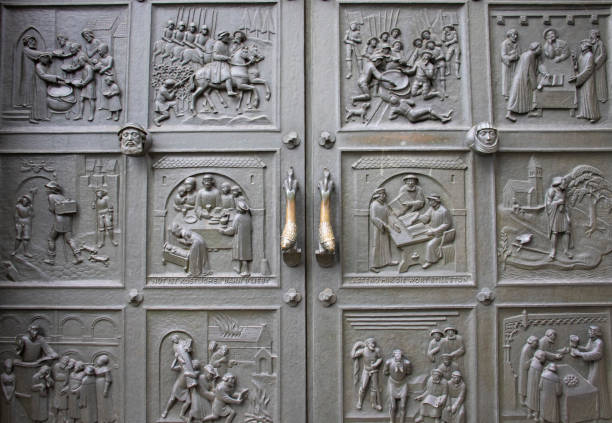 Zurich, Switzerland - November 2019: Ornated bronze external door showing reformation scenes created by Otto Münch in the Grossmünster Church