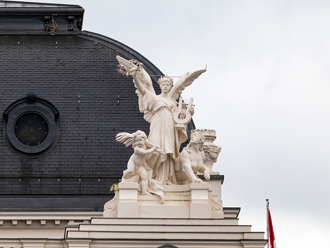 Zurich, Switzerland - November 2019: Detail of statue located in the roof of the Zurich Opera House featuring an angel, an sphynx and a young boy