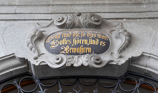Detail of the side entrance of St Peter Church featuring inscription in german