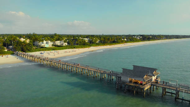 spiaggia di napoli e molo di pesca al tramonto, florida - florida naples florida pier beach foto e immagini stock