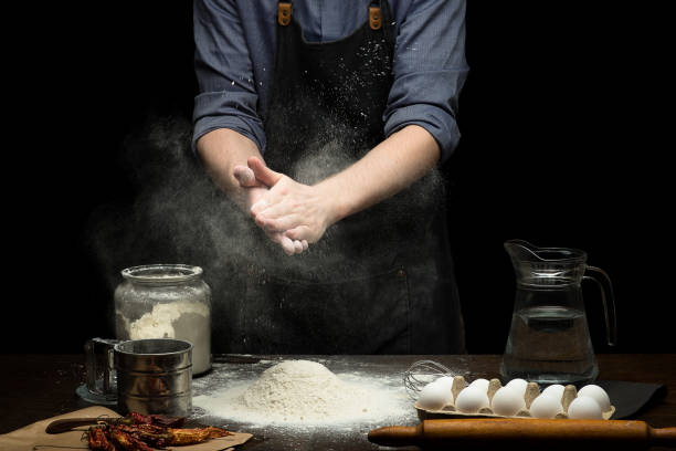 istock Hand strewing flour to make a dough on wooden table 1250525897