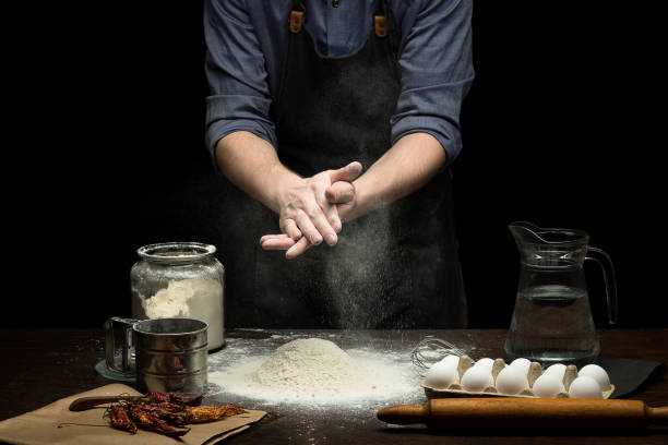 istock Hand strewing flour to make a dough on wooden table 1250525955