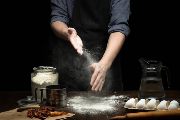 istock Hand strewing flour to make a dough on wooden table 1250526038