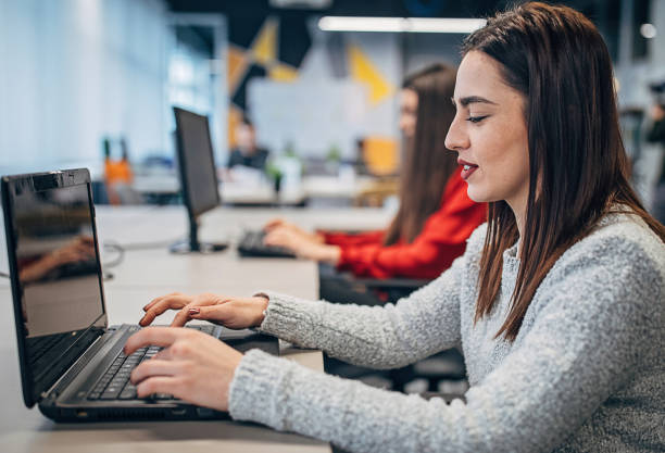istock Beautiful women working on laptops in big modern office 1250526116