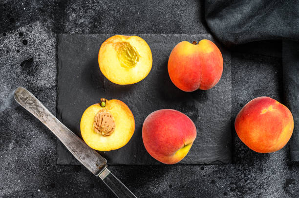 istock Organic Peaches fruit on a black stone Board. Black background. Top view 1250529651