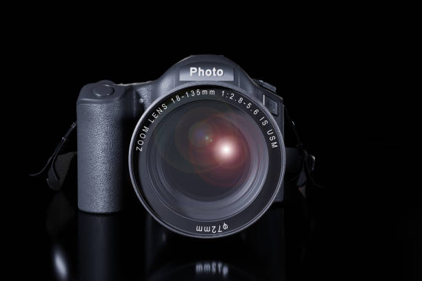 istock Front view of professional digital single lens reflex camera with a zoom lens and a strap on a black background with copy space. Realistic 3d render. Place for advertising text. Reflection at bottom 1250533324