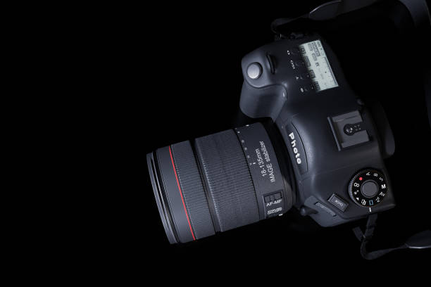 istock Top view professional digital camera with a zoom lens and a leather strap on a black background with copy space. View from above. Realistic 3d render. Place for advertising text. Reflection at bottom 1250533332
