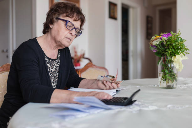 istock Serious mature woman calculating bills 1250538328