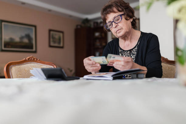 istock Elderly woman counting money 1250538386
