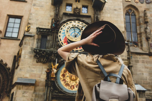 blonde mädchen mit hut und rücken in der nähe von berühmten uhr in prag, tschechische republik - beautiful horizontal prague czech republic stock-fotos und bilder