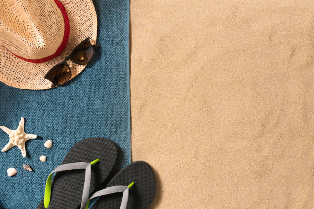 istock Summer vacation composition. Flip flops, hat and sunglasses on sand background. Travel vacation concept. Summer background. Border composition made of towel 1250539687