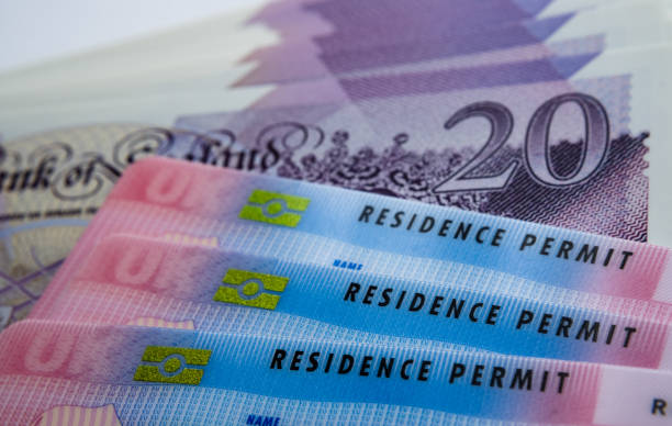 UK Biometric Residence permit cards and 20 pound banknotes. BRP cards released for Tier 2 work visa immigrants. stock photo