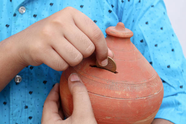 istock Saving,money,future,hand,coin,a boy saving money for future 1250543162