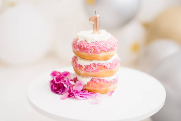 istock donut cake with one candle on a stand with pink flowers 1250544989