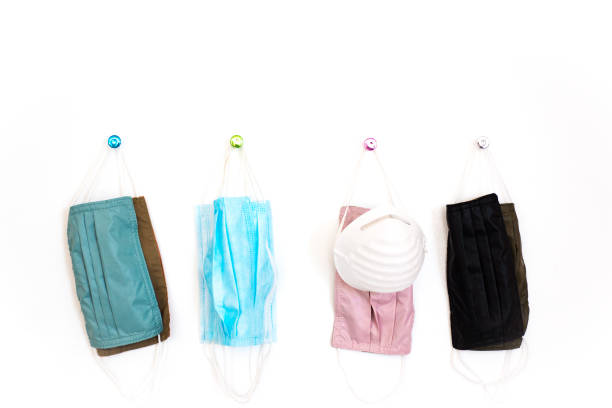 istock Colorful Protective Masks Hanging on Wall, White Background 1250545391
