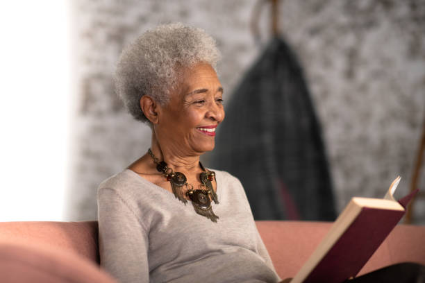 istock Senior woman reading happily at home 1250547083