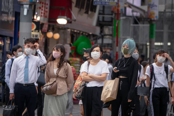 Crowd of people with face masks walking in shibuya crossing Shibuya, Tokyo, Japan - June 10, 2020: Crowd of people with face masks walking in the famous tourist place shibuya crossing, after the state of emergency expires, rush hour tokyo crowds on the famous shibuya crossing japan stock pictures, royalty-free photos & images