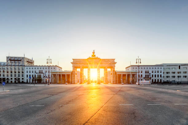 beau lever de soleil directement derrière la porte de brandebourg, berlin, allemagne - berlin germany urban road panoramic germany photos et images de collection