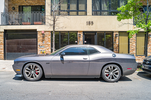 A gray colored Dodge Challenger SRT 392 is parked on a street in Brooklyn, New York City, USA on a sunny day.