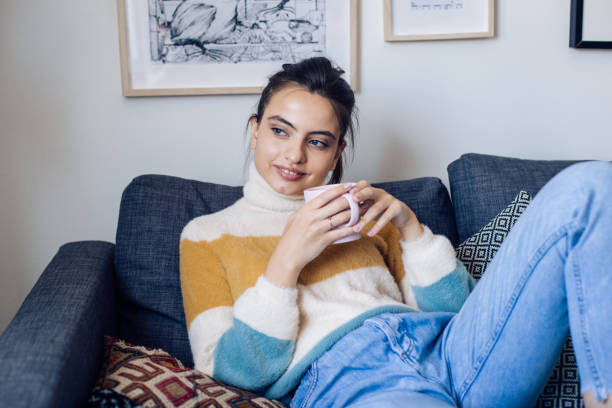 istock Beautiful girl drinking coffee and enjoying on the sofa 1250551290