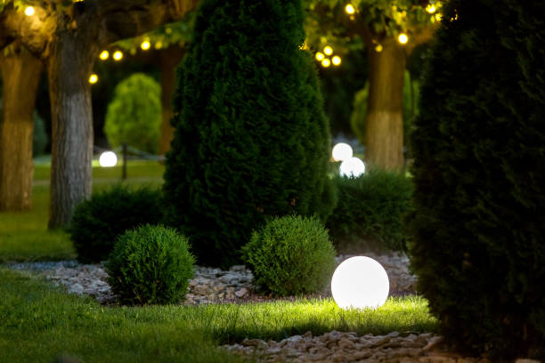 istock backyard light garden with lantern electric lamp with a round diffuser in the green grass with thuja bushes in a park with landscaping, closeup night scene nobody. 1250557241