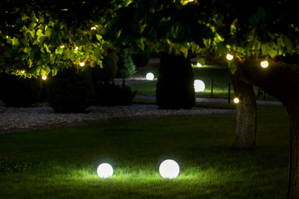 istock illumination backyard light garden with electric ground lantern with round diffuser lamp with garland of light bulbs on a tree branch with leaves with landscaping, dark illuminate night scene nobody. 1250557243