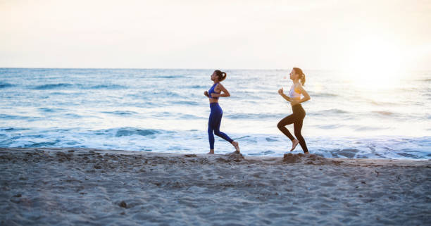 istock Female Friends Running On The Beach. 1250558387