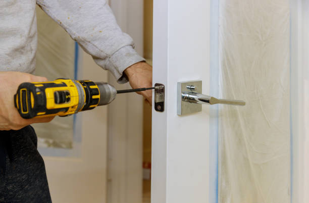 istock Handyman using a drill to installing lock in door in a house 1250559428