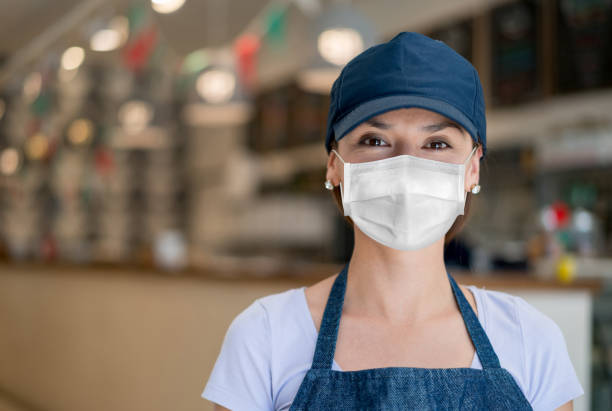 istock Waitress working at a restaurant wearing a facemask to avoid the spread of coronavirus 1250559976