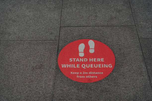 istock Stand here while queuing sign on a street in London, UK. 1250560733