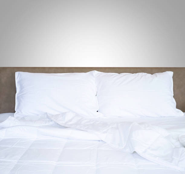 istock Front view of clean white soft pillows with duvet and bed sheets on the comfortable bed in the bedroom. 1250560749
