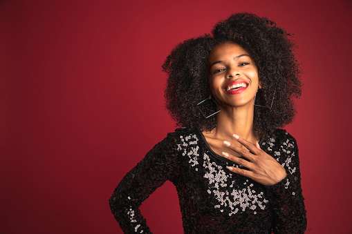 An African American woman on a bright background ready to have fun.