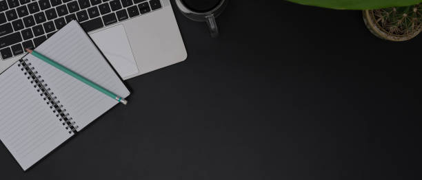 istock Dark modern workspace with open blank schedule book, laptop, decorations and copy space 1250571332