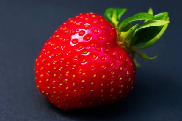 istock One big strawberry on a dark background. Close-up. 1250572495