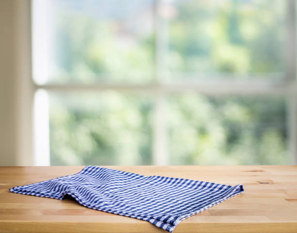 istock Blue checked tablecloth on wood with blur green bokeh from window kitchen background. 1250576674