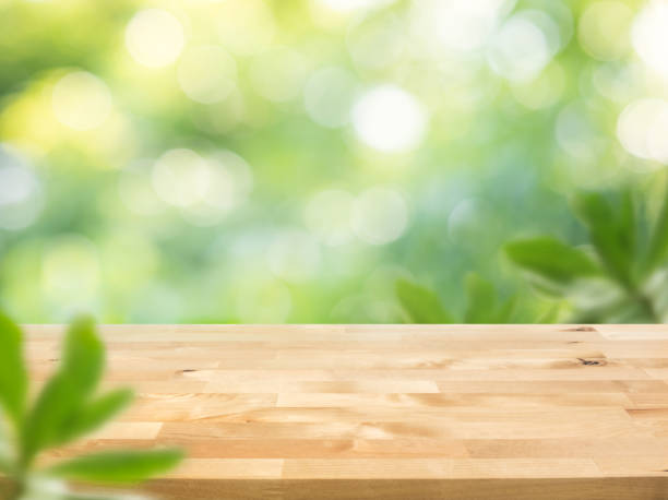 istock Real wood table top texture on blur leaf tree garden background 1250576737