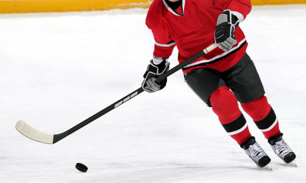 istock Ice hockey player dribbling puck on rink 1250577637