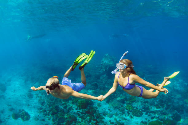 young couple in snorkeling mask free dive underwater in sea - nusa lembongan bali island beach imagens e fotografias de stock