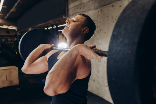 istock muscular fit guy training with barbell 1250582997