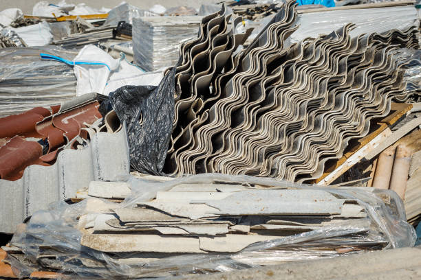 Damaged asbestos roofing material. Roof covering material with asbestos fiber Damaged asbestos roofing material. Roof covering material with asbestos fiber asbestos abatement stock pictures, royalty-free photos & images