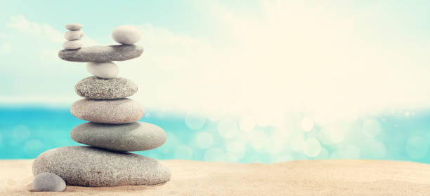 istock Pyramid of sea pebbles on a sunny sand beach 1250586383