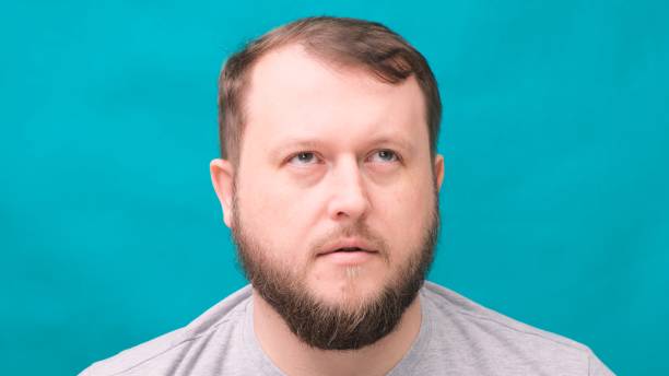 istock bearded man looks surprised in horror on a green background 1250587571