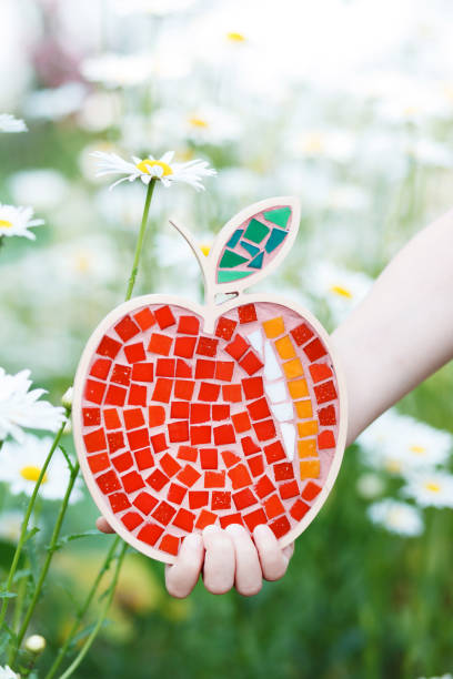 istock Red apple with mosaic on a background of daisies. 1250589924