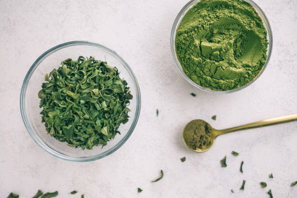 istock Green moringa leaf powder. Moringa leaf tea. green powder on white background 1250590864