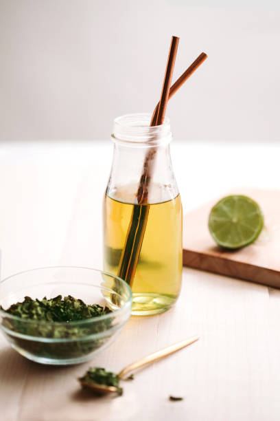 istock Glass bottle with moringa leaf tea, recyclable drinking straws made with stainless steel, moringa dry leaves and powder on wooden table. 1250590915