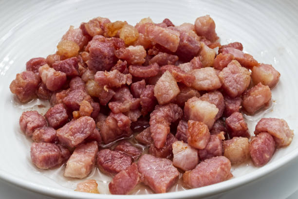 istock Bacon cubes in ceramic bowl, isolated on white background 1250592506