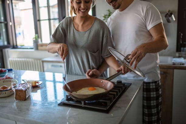 istock Making eggs for breakfast. Young couple in the kitchen 1250592513