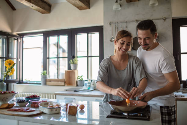 istock Making eggs for breakfast. Young couple in the kitchen 1250592545
