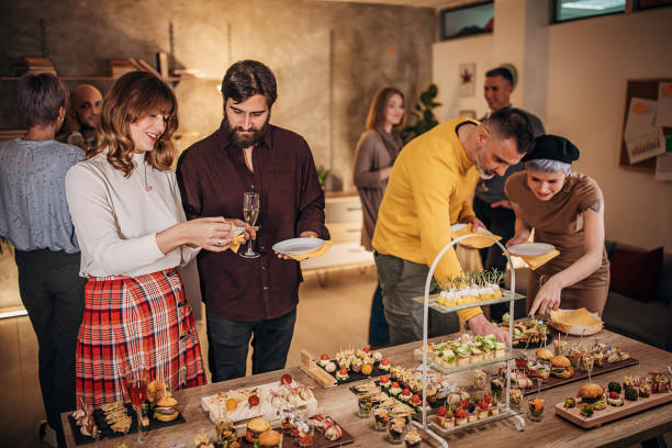 istock Business colleagues sampling savory dishes at corporate office party 1250596341