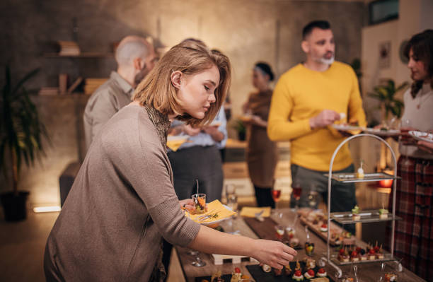istock Business colleagues sampling savory dishes at corporate office party 1250598047